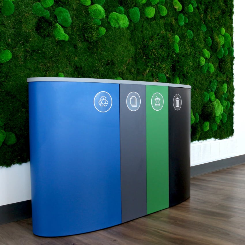 quad waste and recycling container system in a modern office up against a green living wall