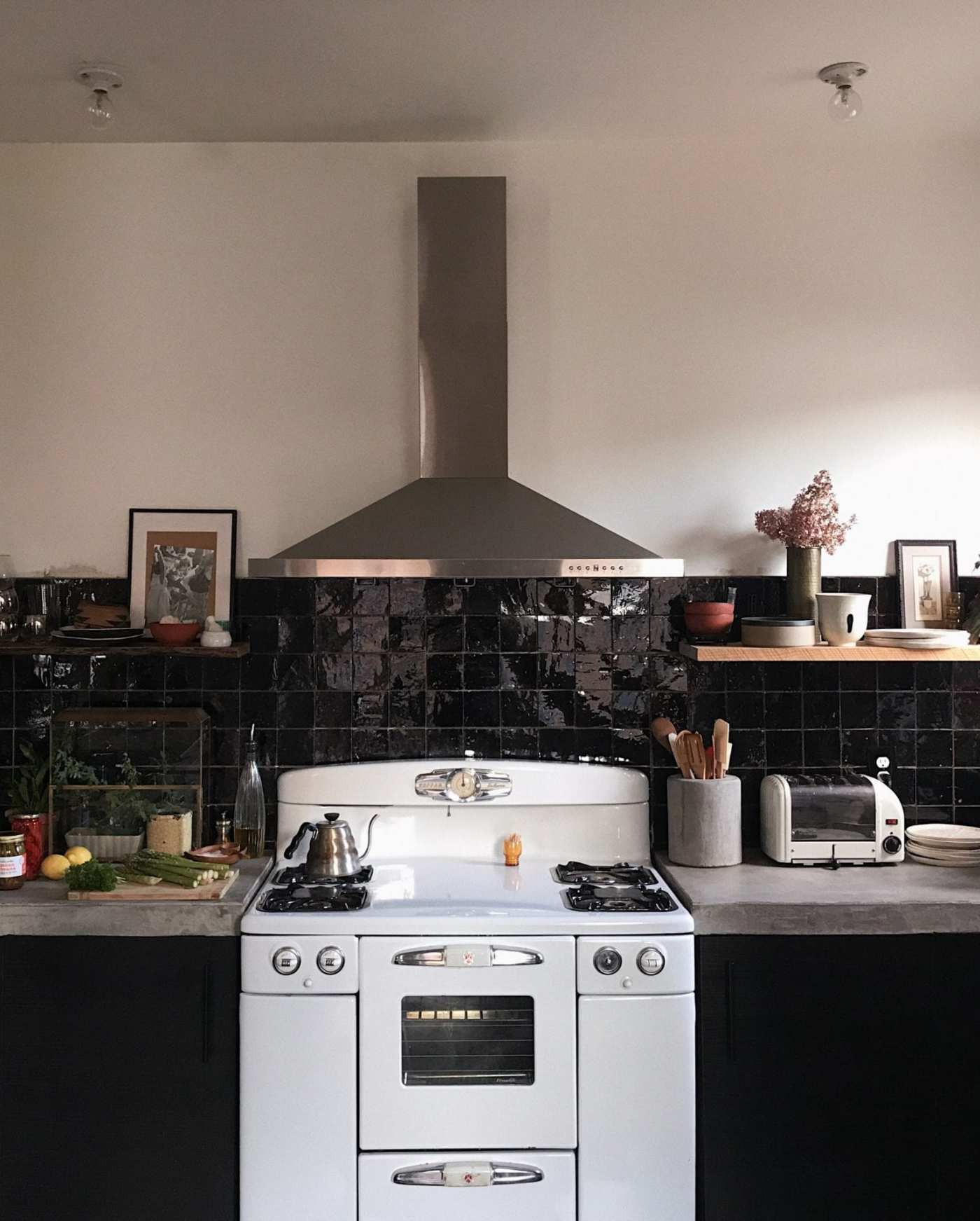 a kitchen with a black tile backsplash.