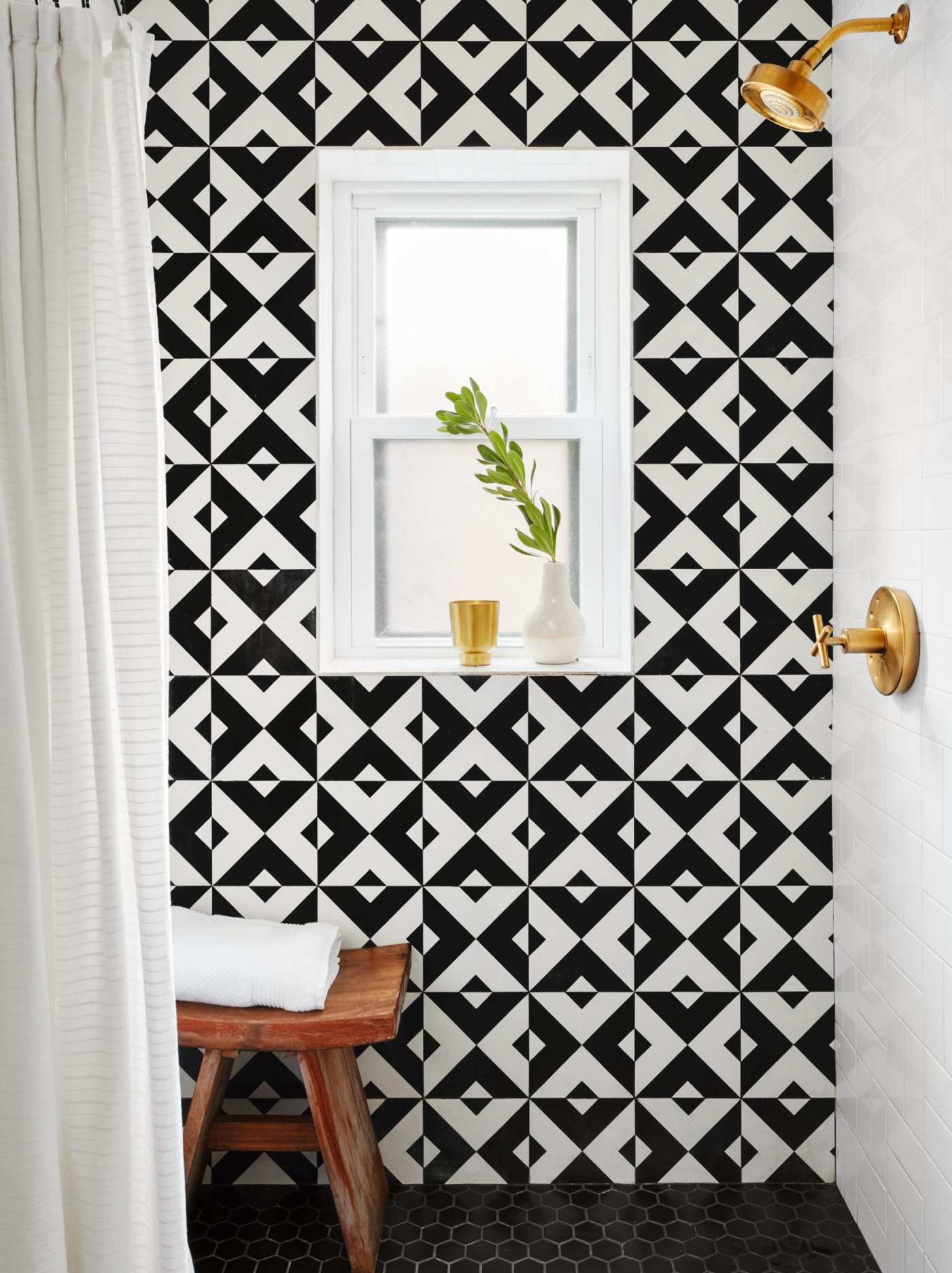 a bathroom with a black and white tiled wall.