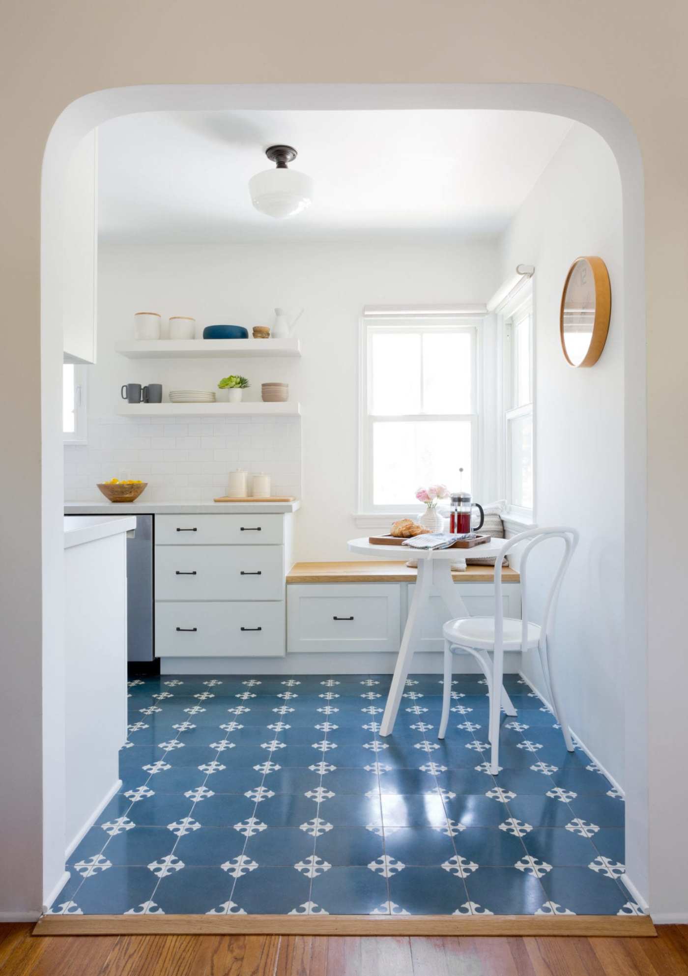 a blue and white kitchen with a white table and chairs.