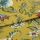 Mustard-yellow fabric with botanical green leaves and red-and-blue flowers, folded once with overlapping edge; close-up studio-lit view of the textile on a flat surface.