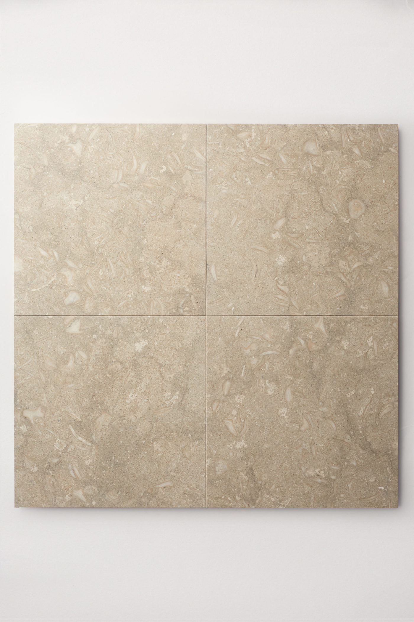 four square beige tiles on a white surface.