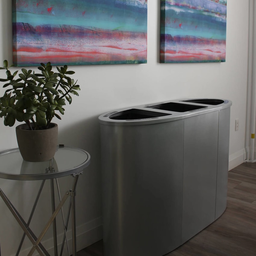 triple opening trash and recyclables station with silver powder coated steel body in an upscale office