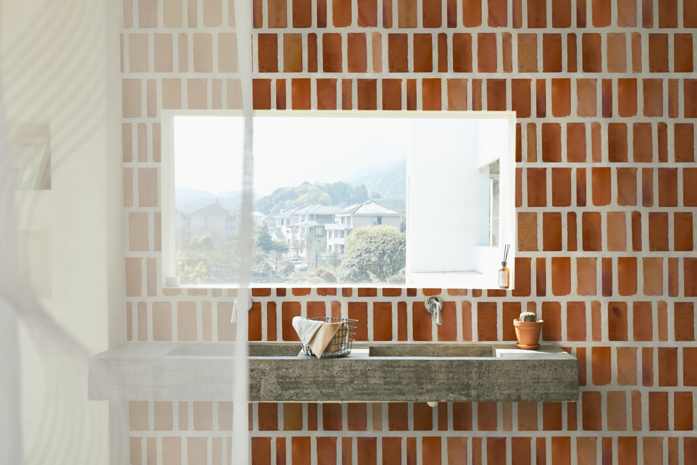 a bathroom with a sink, a mirror and a red tiled backsplash wall.