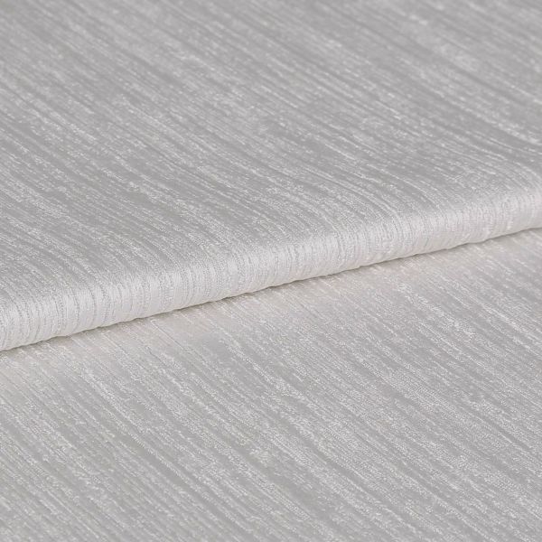 Textured ivory curtain fabric, folded over itself showing horizontal ribbed sheen; close-up view on a neutral surface with soft, diffuse lighting highlighting the weave.