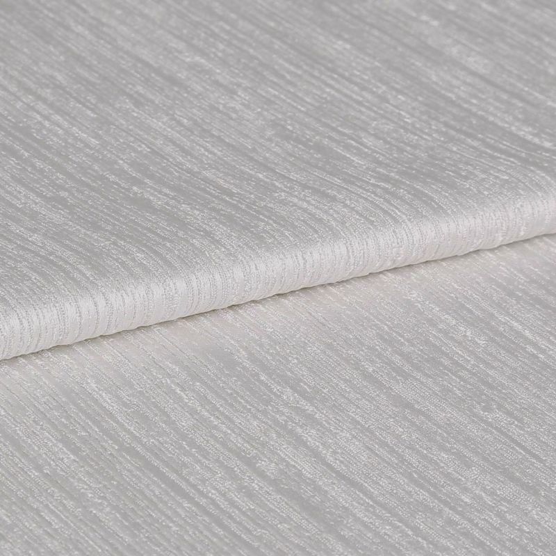 Textured ivory curtain fabric, folded over itself showing horizontal ribbed sheen; close-up view on a neutral surface with soft, diffuse lighting highlighting the weave.