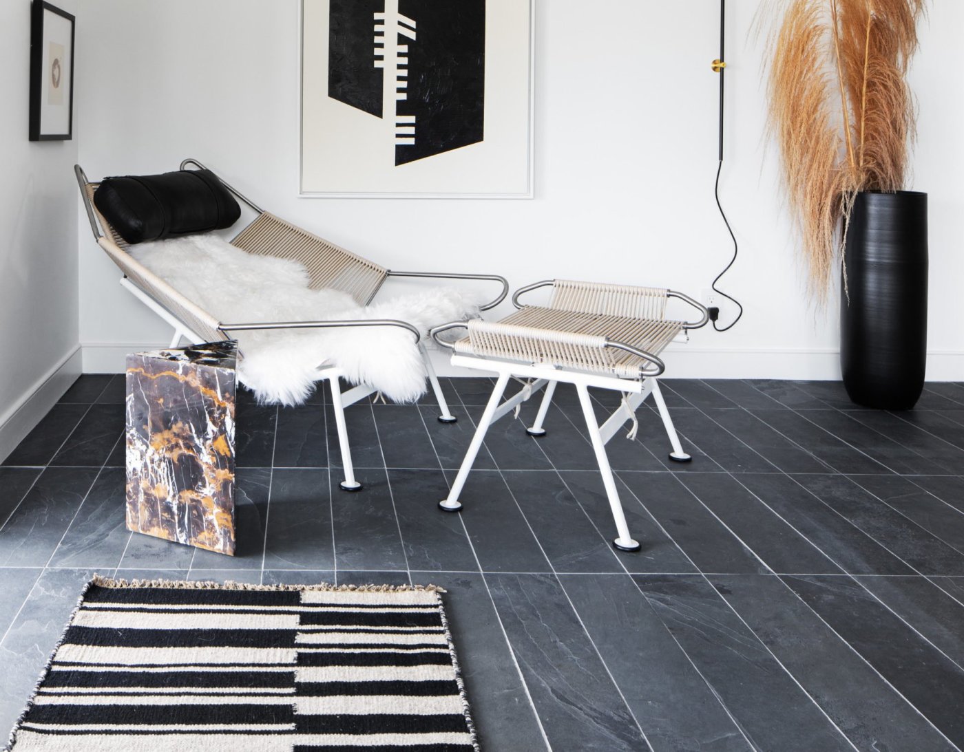 a black and white living room with a chair and a rug.