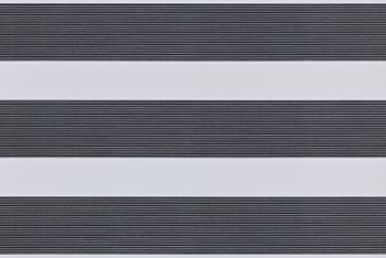Dual-layer horizontal zebra roller blind mounted across the frame, aligned into alternating wide opaque white bands and narrow ribbed dark-gray slats, partially filtering light; interior close-up with soft even lighting.