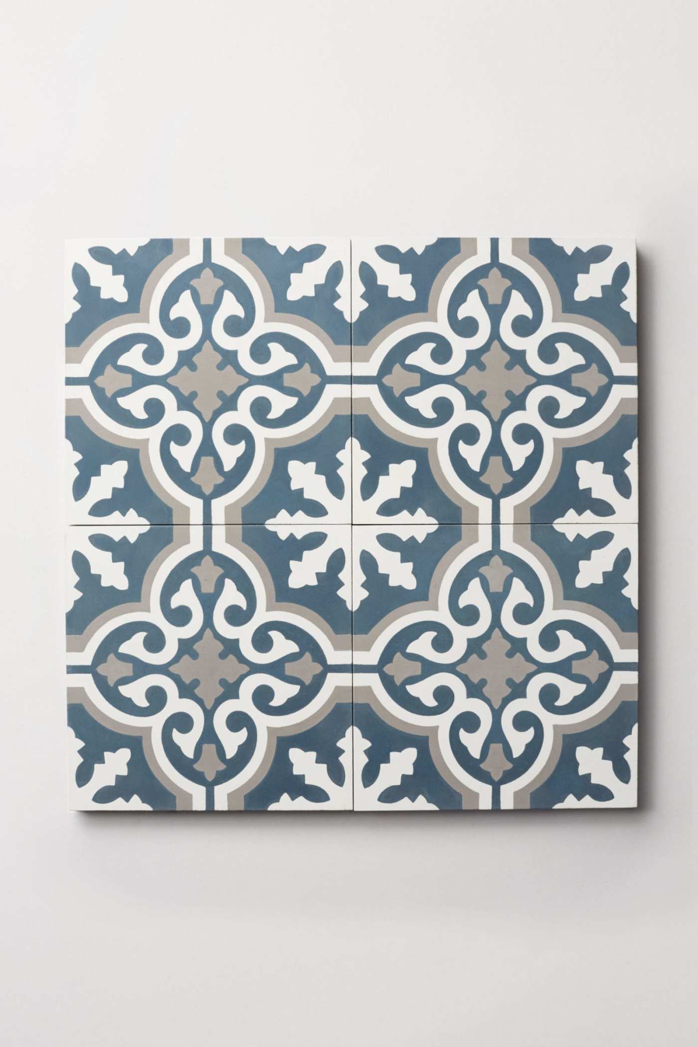 four blue and white tiles with ornate designs.