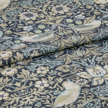A folded upholstery fabric panel with bird-and-floral tapestry print; folded over itself, revealing textured weave; close-up view in muted blue, cream, and sage tones.