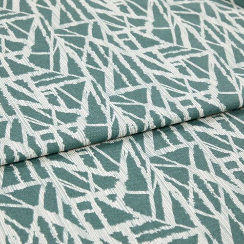 Folded teal-and-white fabric with angular abstract geometric print, folded across the center, showing overlapping layers and ribbed weave; close-up on a flat surface under soft, even lighting.