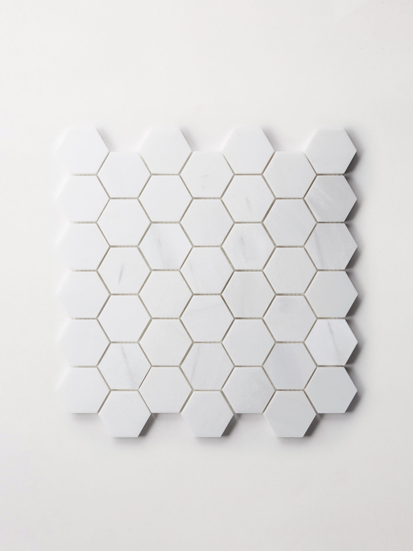 a sheet of small white hexagon tiles on a white background.