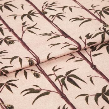 Folded fabric sample in blush pink background with linear print of bamboo shoots and leaves.