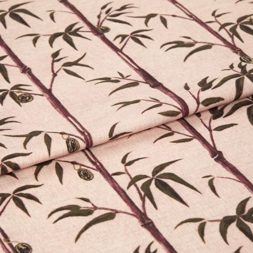 Folded fabric sample in blush pink background with linear print of bamboo shoots and leaves.
