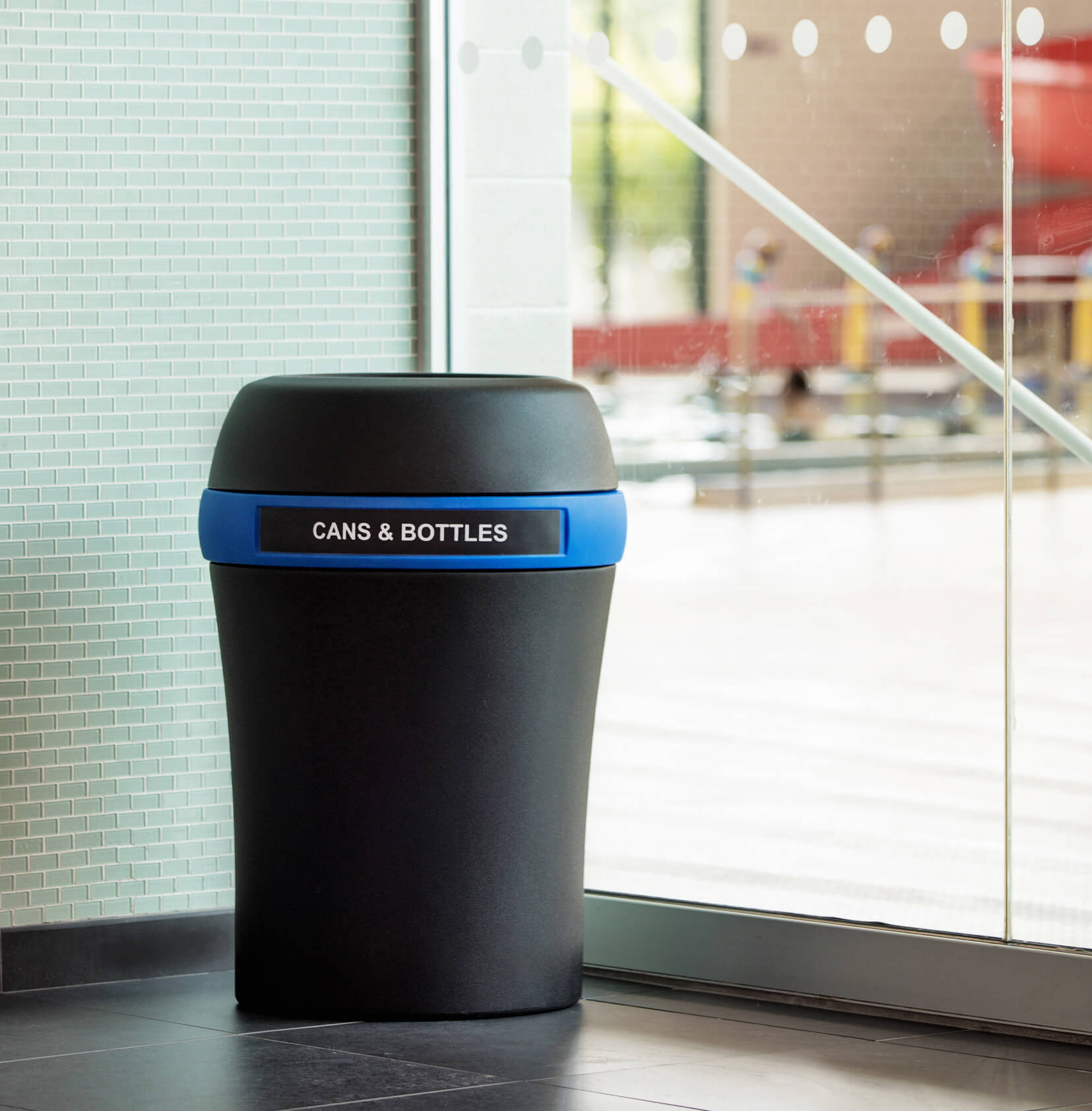black plastic recycling container for cans and bottles in a recreation facility