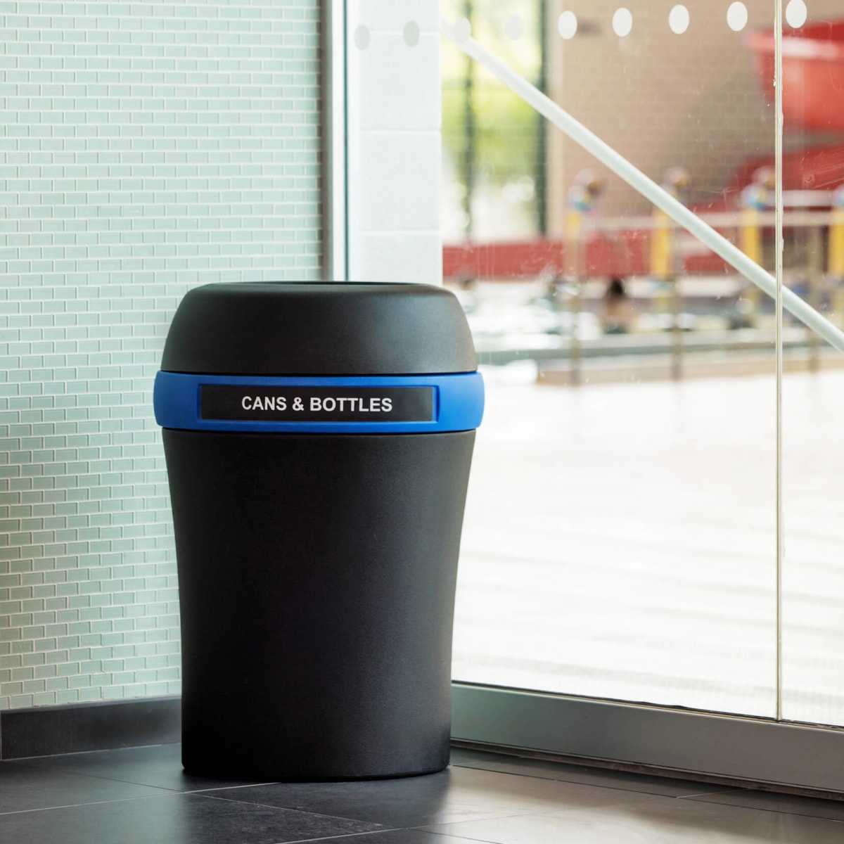 black plastic recycling container for cans and bottles in a recreation facility