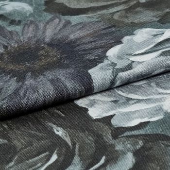 Dark floral upholstery fabric folded across the frame, coarse woven texture and oversized gray-white flower prints visible; fabric layered on itself under soft, even lighting in a close-up studio-style view.