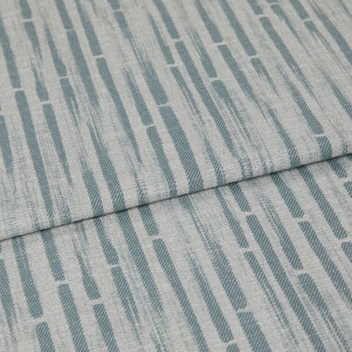 Textured light-gray upholstery fabric patterned with vertical teal elongated dashes; folded across the center, overlapping; close-up studio view showing woven texture under soft, even lighting.