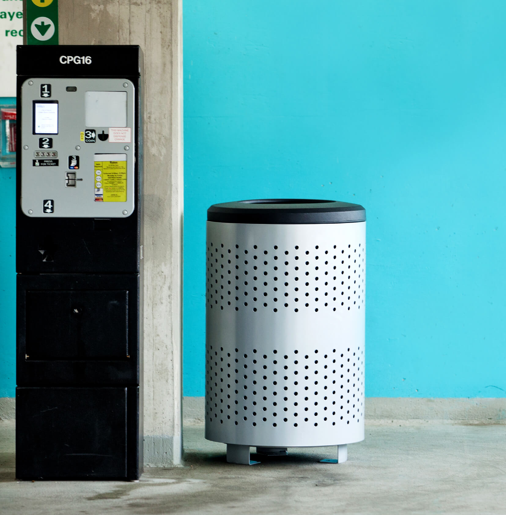 durable powder coated steel waste bin in a parking garage beside the pay station