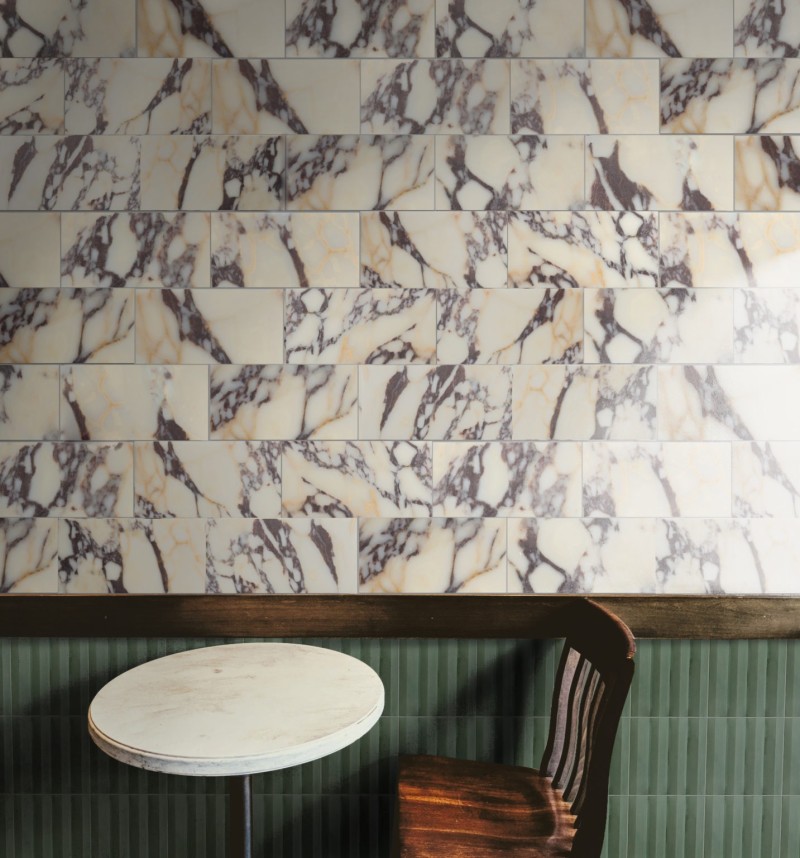 a table and chairs in front of a marble wall.