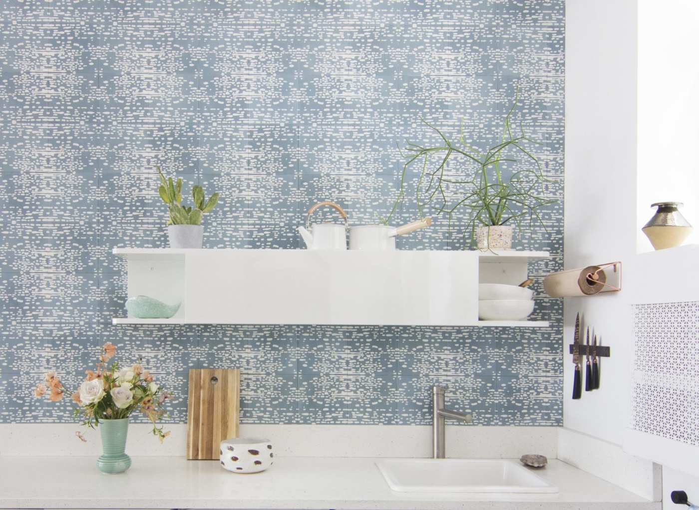 a blue and white tiled sink backsplash in a kitchen.