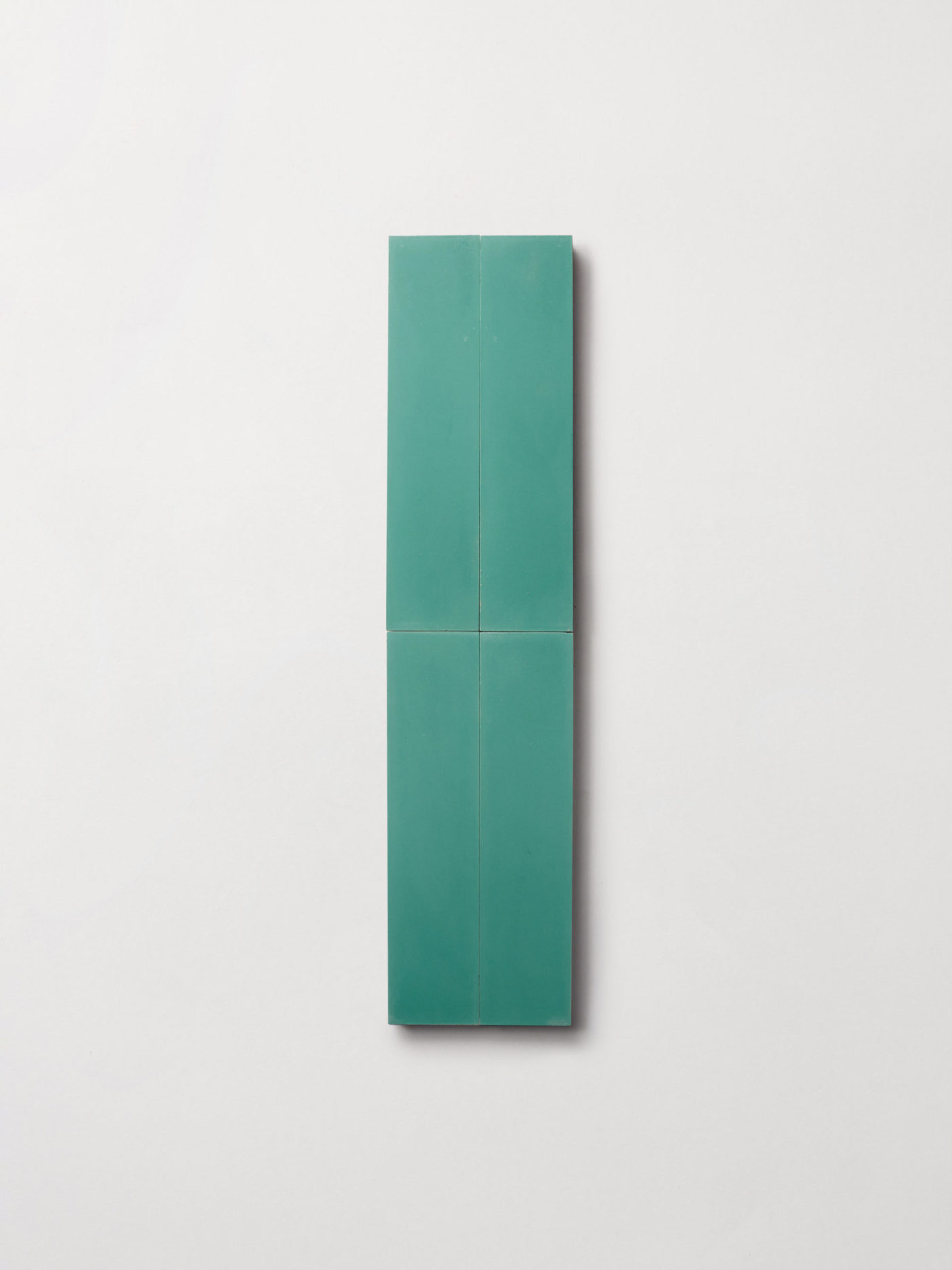 a green rectangle tile hanging on a white surface.