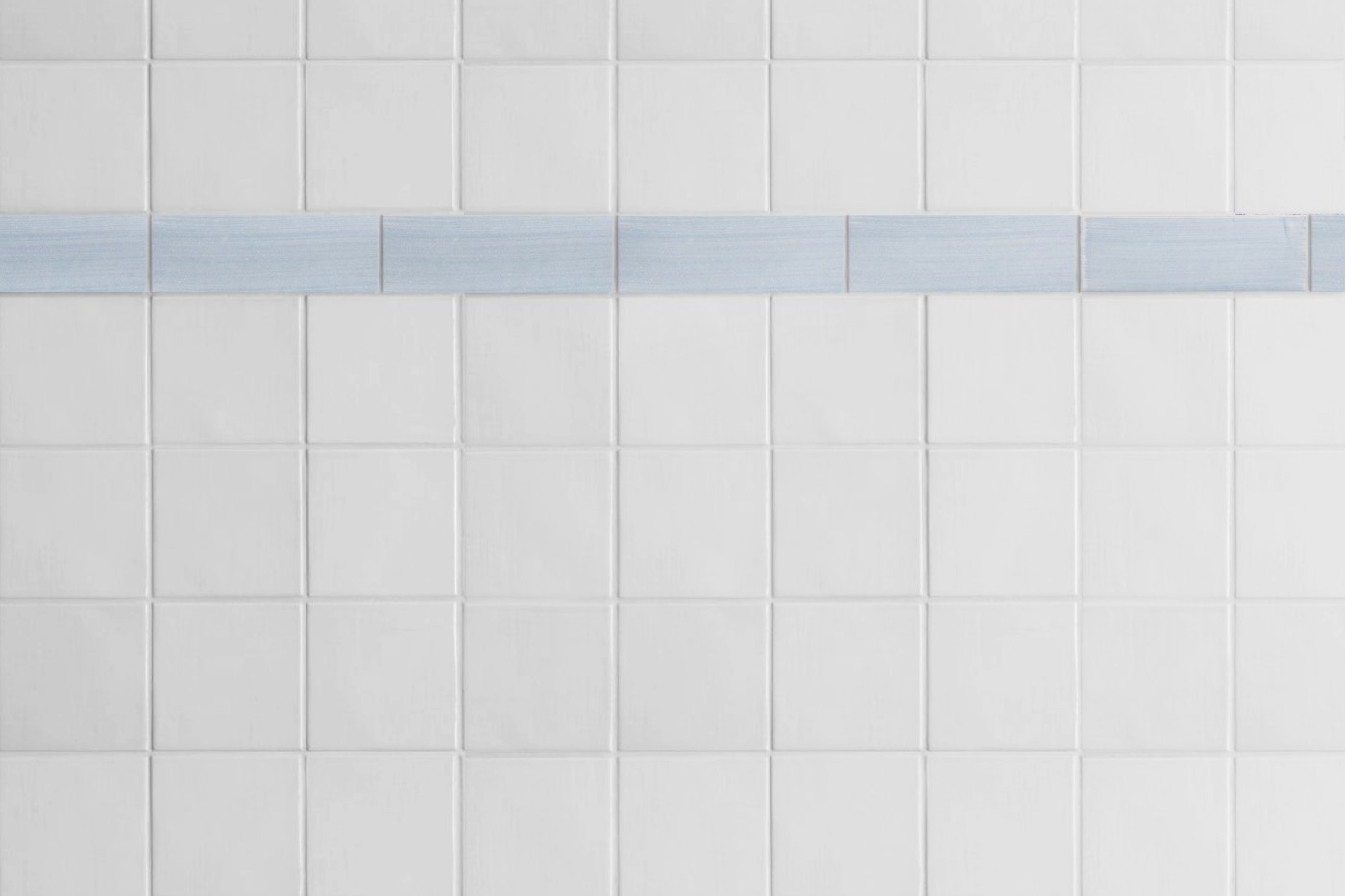 a white tiled wall with a blue stripe.