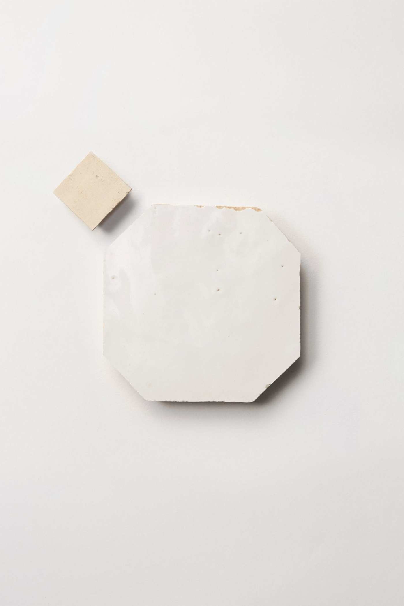 white and tan tiles on a white surface.