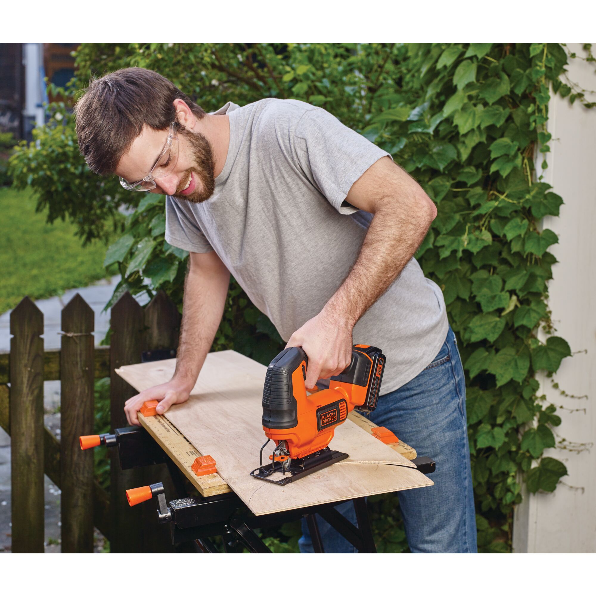 Cordless Jigsaw being used for cutting plywood by person.