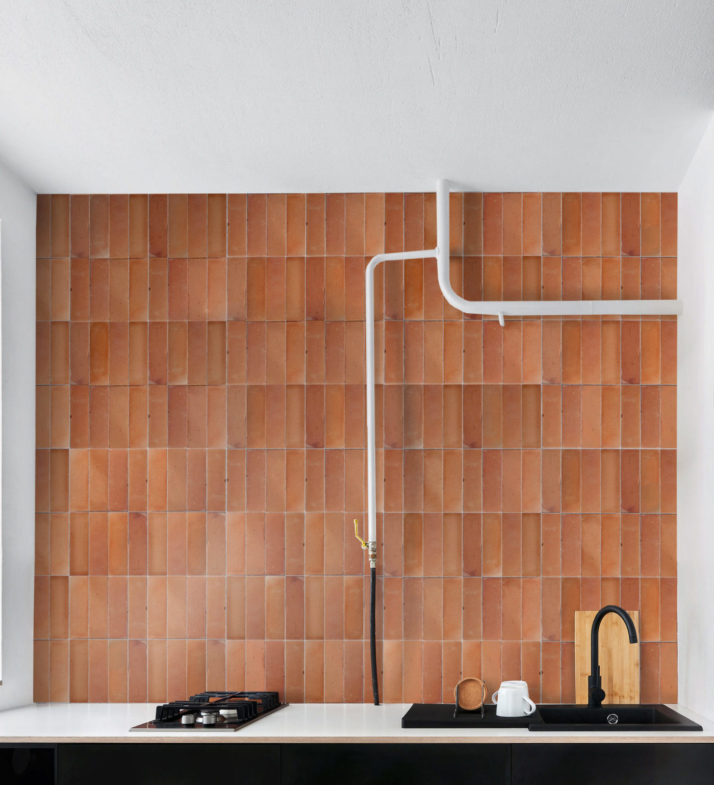 a kitchen with a red tiled backsplash wall.