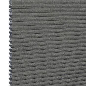 Gray honeycomb (cellular) fabric blind, fully lowered with visible hexagonal cells along the left edge; blocking light, shown in an even, neutral close-up product background.
