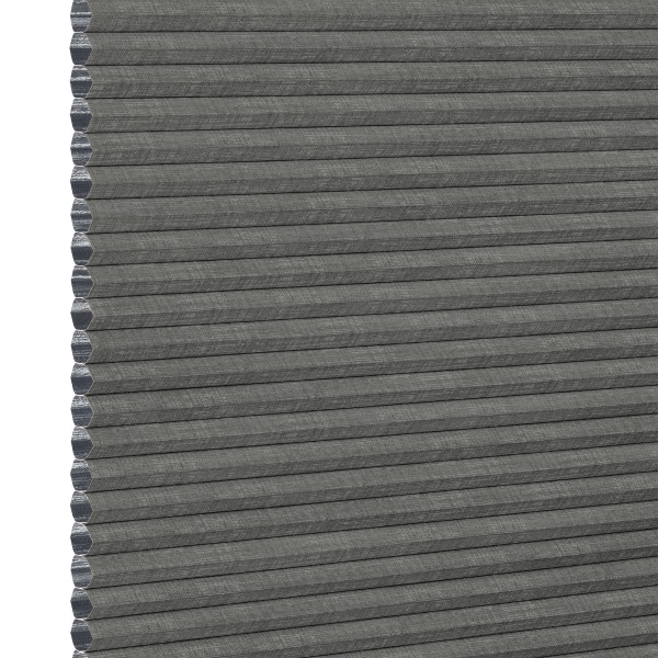 Gray honeycomb (cellular) fabric blind, fully lowered with visible hexagonal cells along the left edge; blocking light, shown in an even, neutral close-up product background.