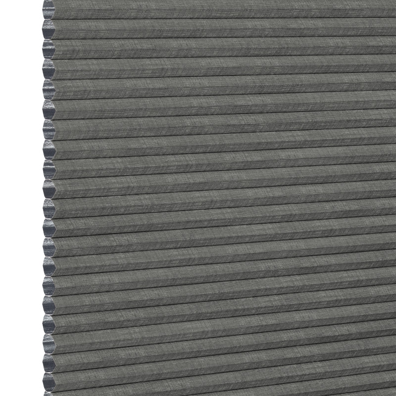Gray honeycomb (cellular) fabric blind, fully lowered with visible hexagonal cells along the left edge; blocking light, shown in an even, neutral close-up product background.