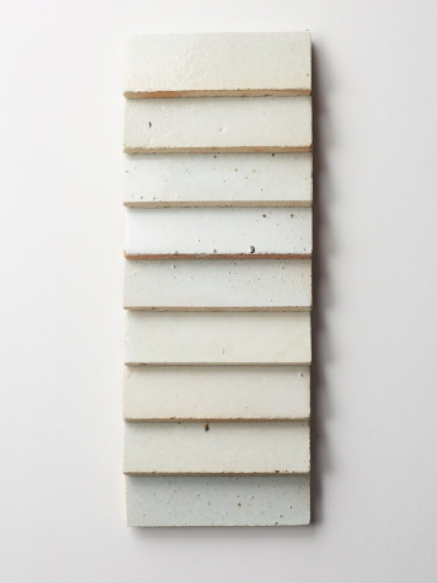 a row of white rectangle tiles on a white surface.