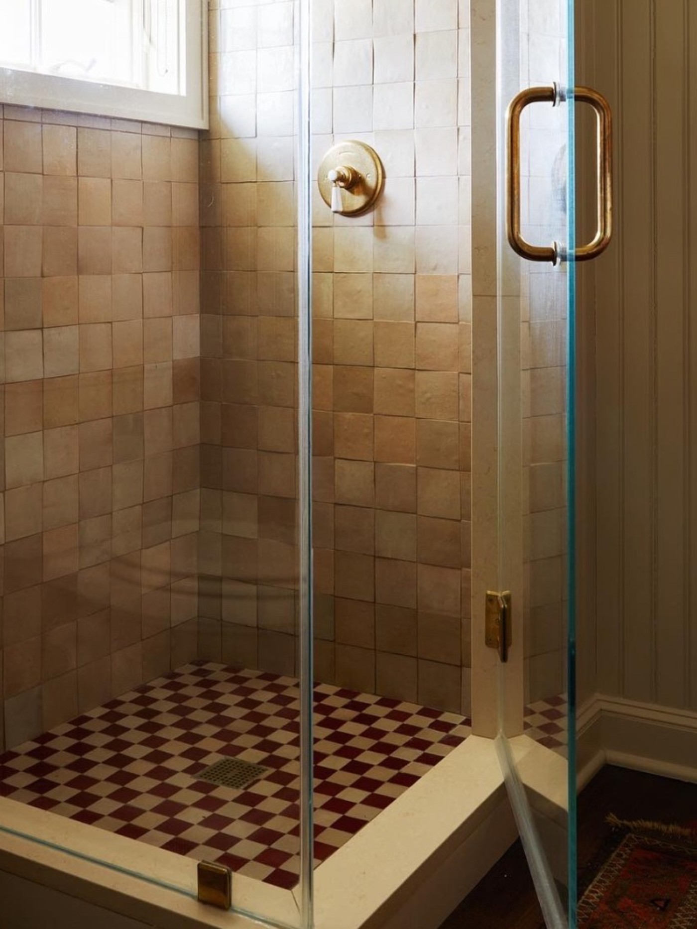 a glass shower stall and a checkered tile shower floor.