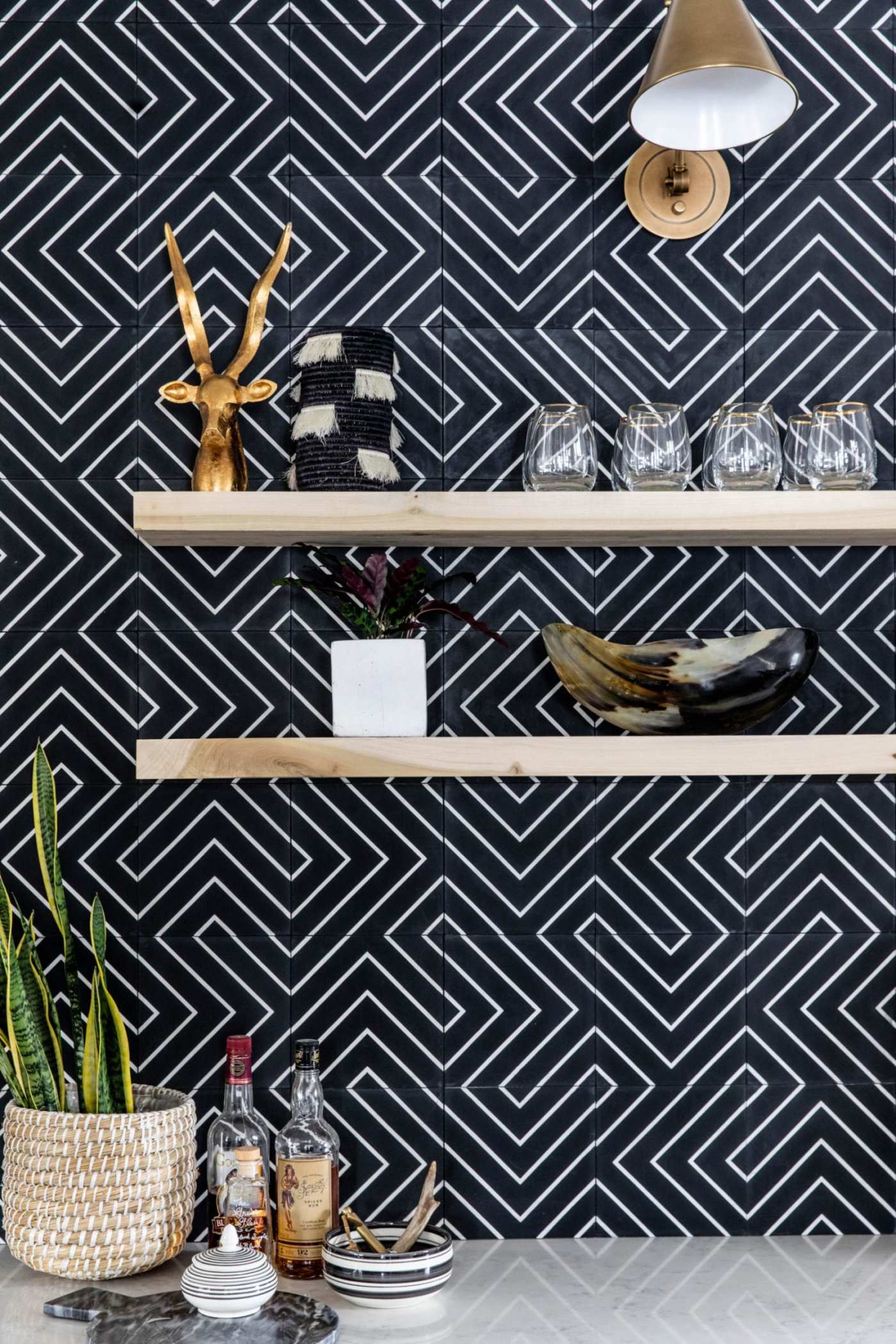 a kitchen with a black and white tiled wall.