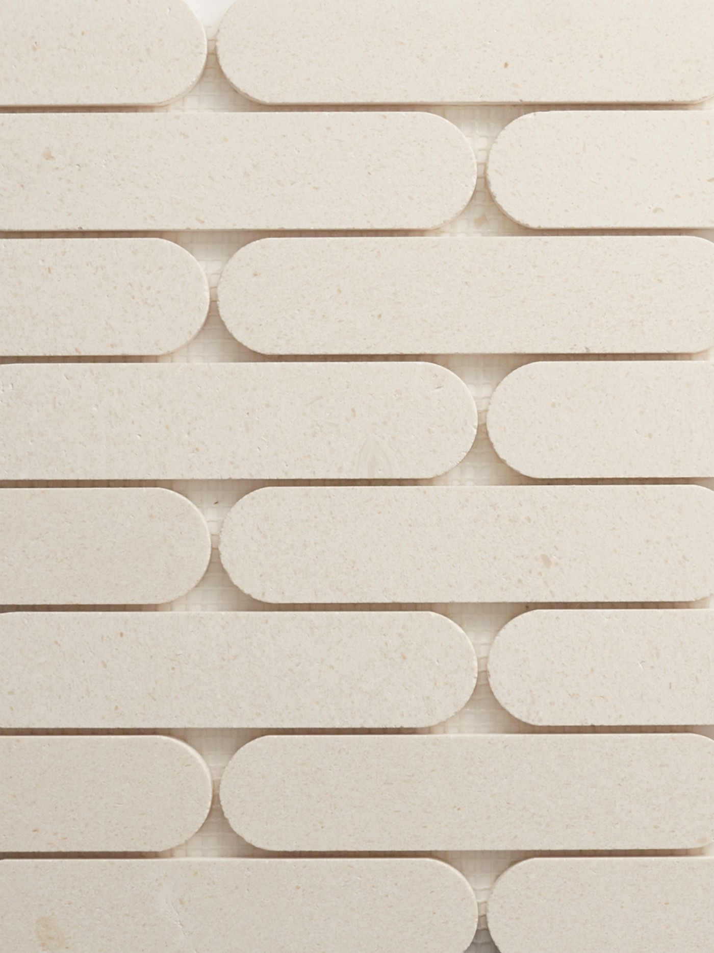 pieces of oval, white marble tile arranged in a pattern.