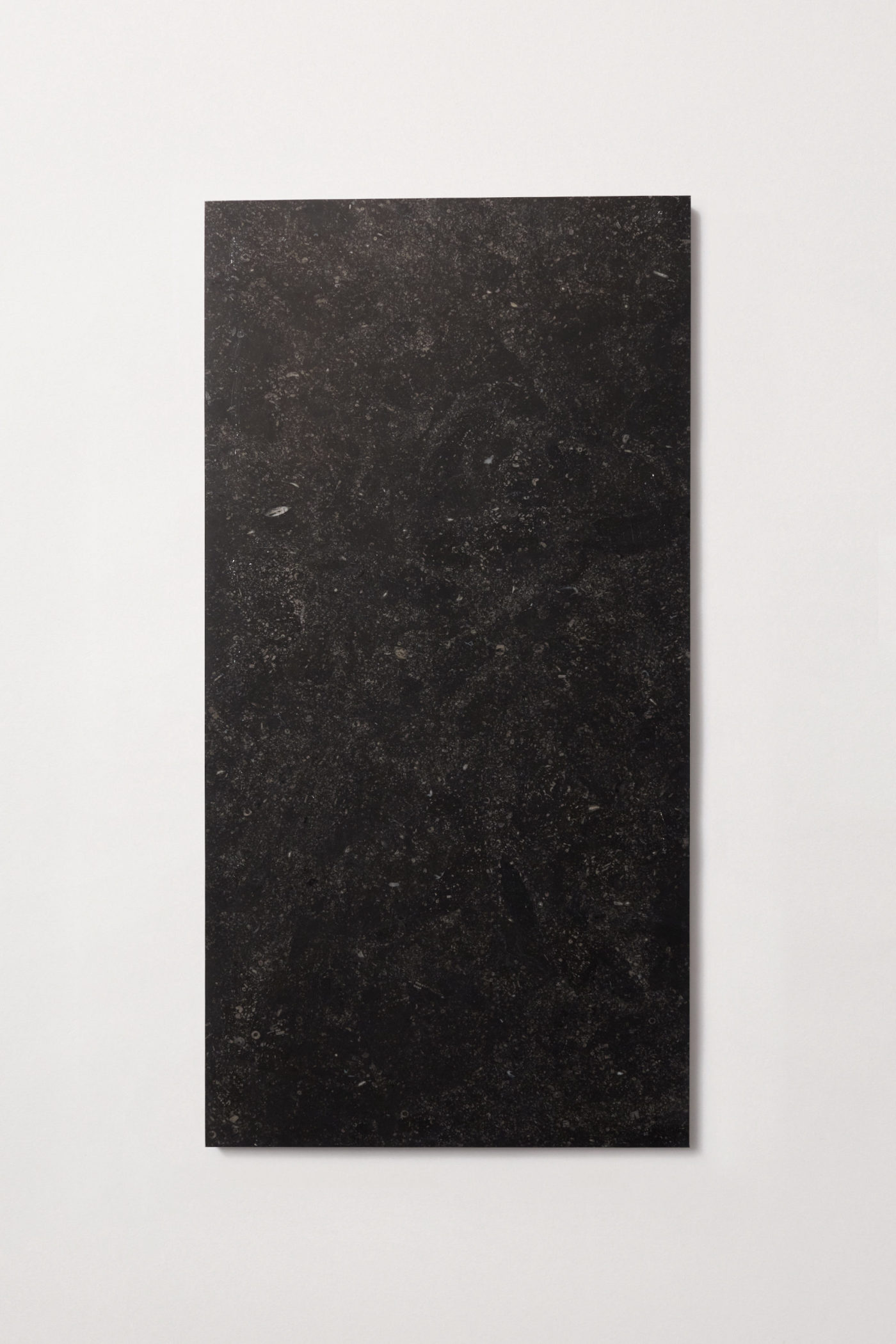 a black rectangle tile on a white surface.