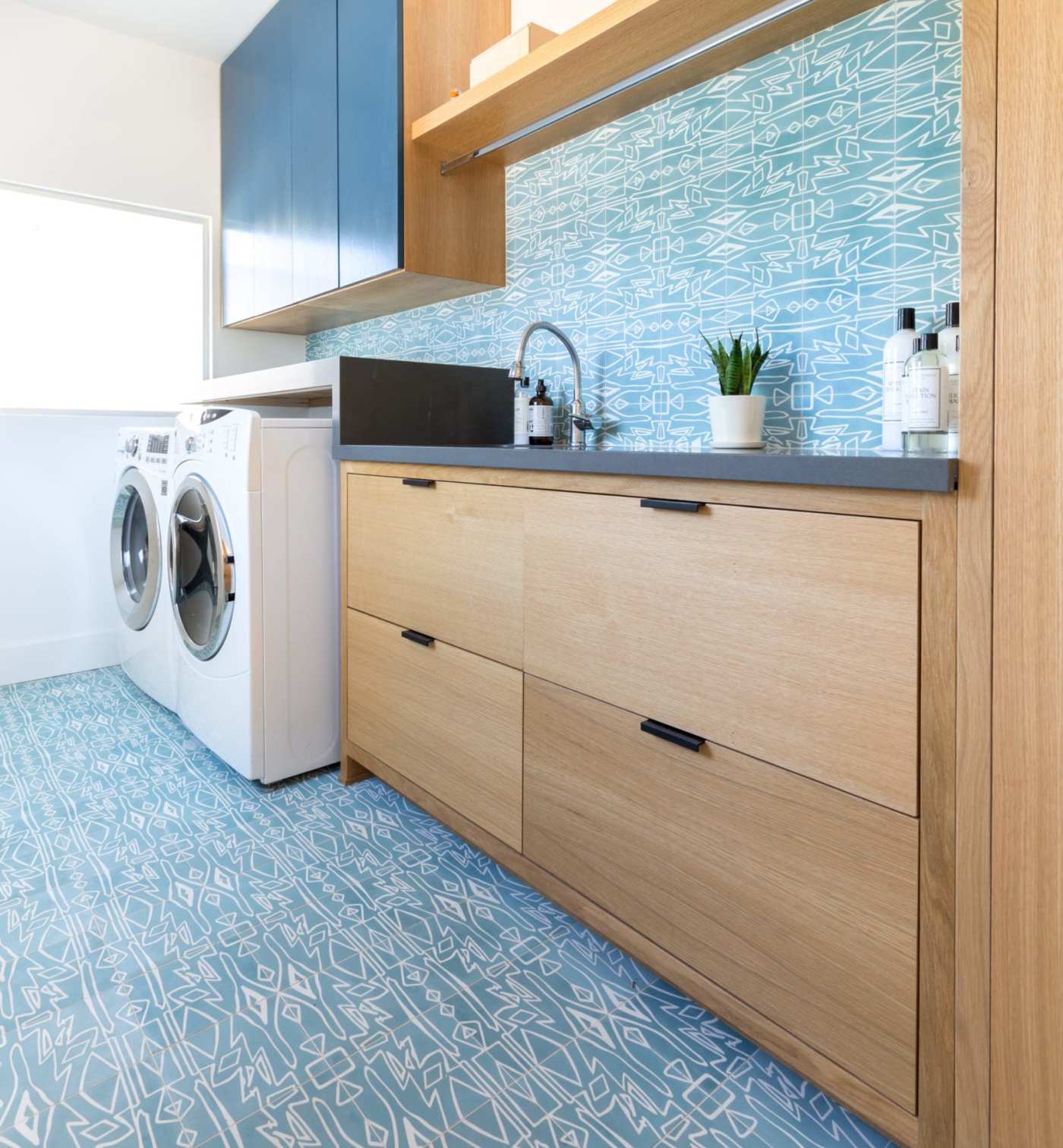 a blue and white laundry room with a washer and dryer.