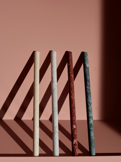 a row of marble pencils on a pink surface.