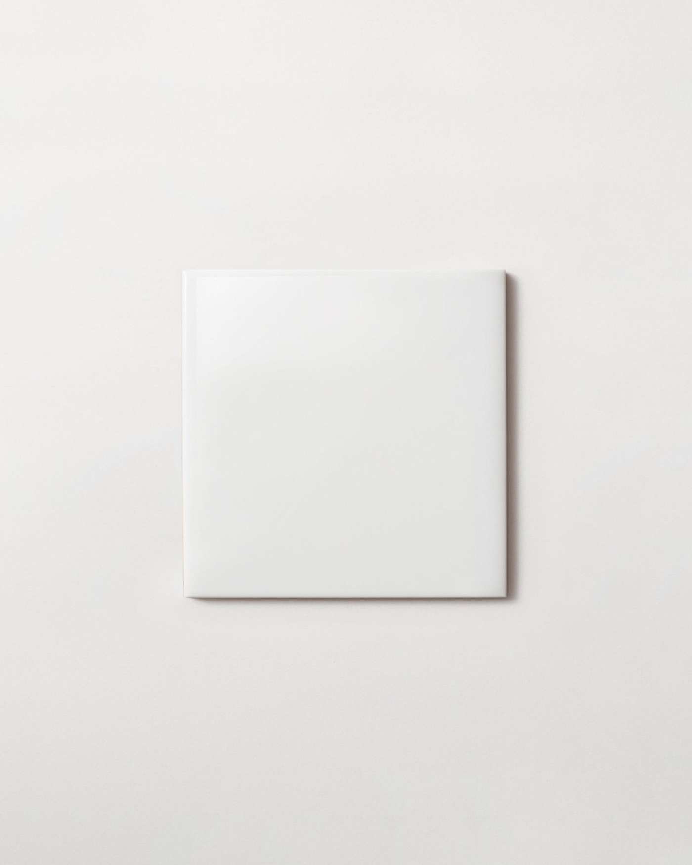 a white square tile on a white surface.