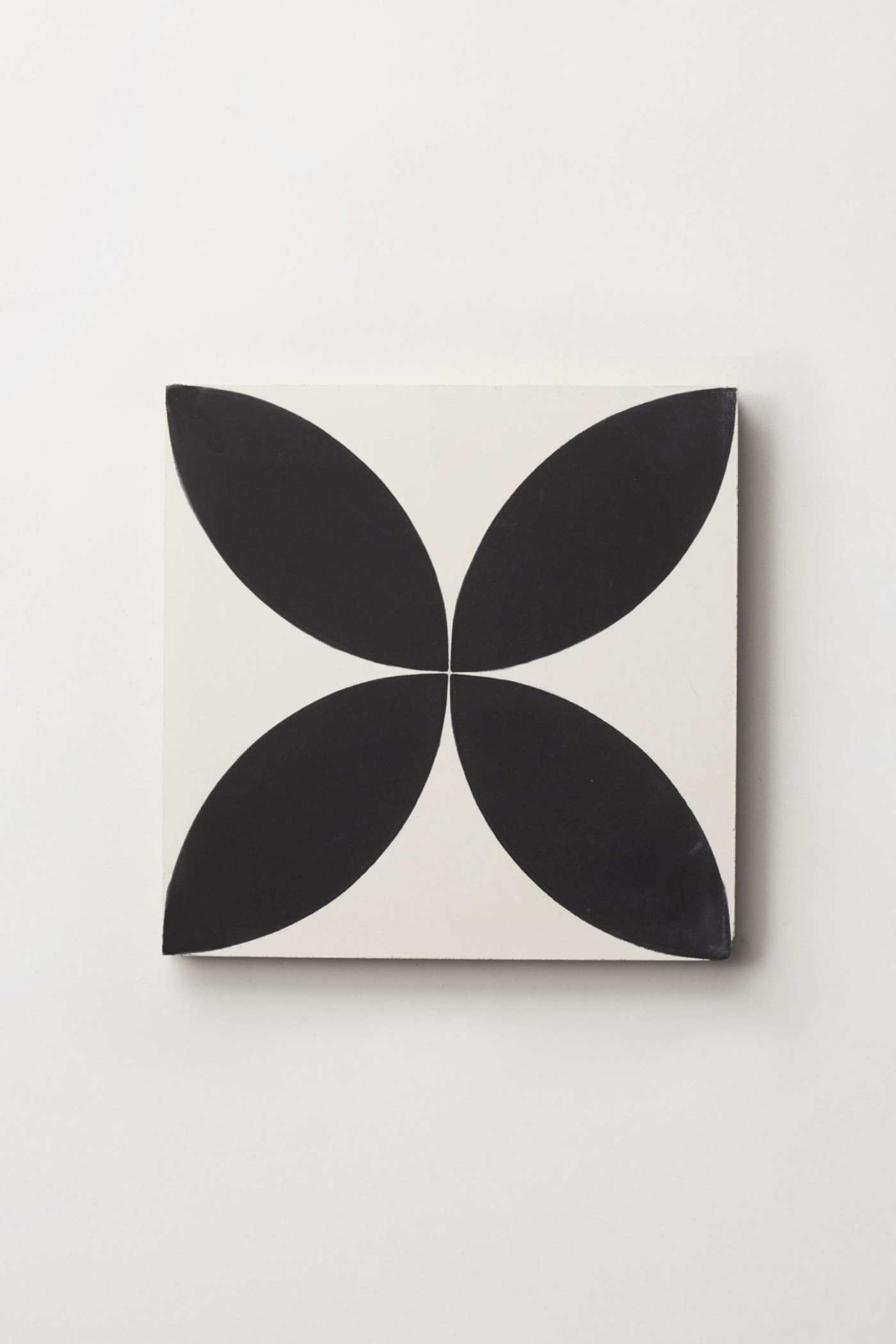 a black and white tile with a flower design on it.