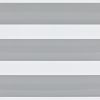 Dual-layer zebra roller blind across a window: alternating opaque white and narrow grey-striped sheer bands, aligned to form horizontal light-and-shade stripes, viewed close-up in a neutral interior setting.