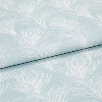 Light blue cotton fabric featuring white peacock-feather motifs, folded once so layers overlap; printed pattern repeats across a soft textile surface in bright, even studio lighting, close-up view.