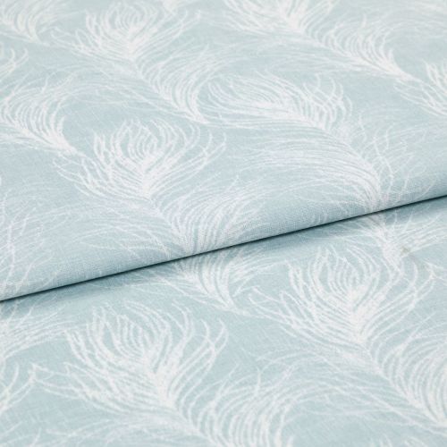 Light blue cotton fabric featuring white peacock-feather motifs, folded once so layers overlap; printed pattern repeats across a soft textile surface in bright, even studio lighting, close-up view.