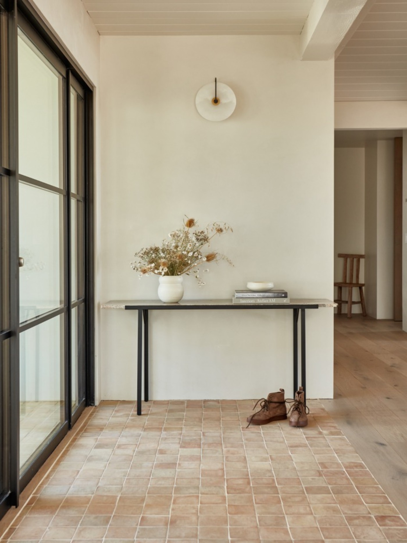 a hallway with a tiled floor and a table.