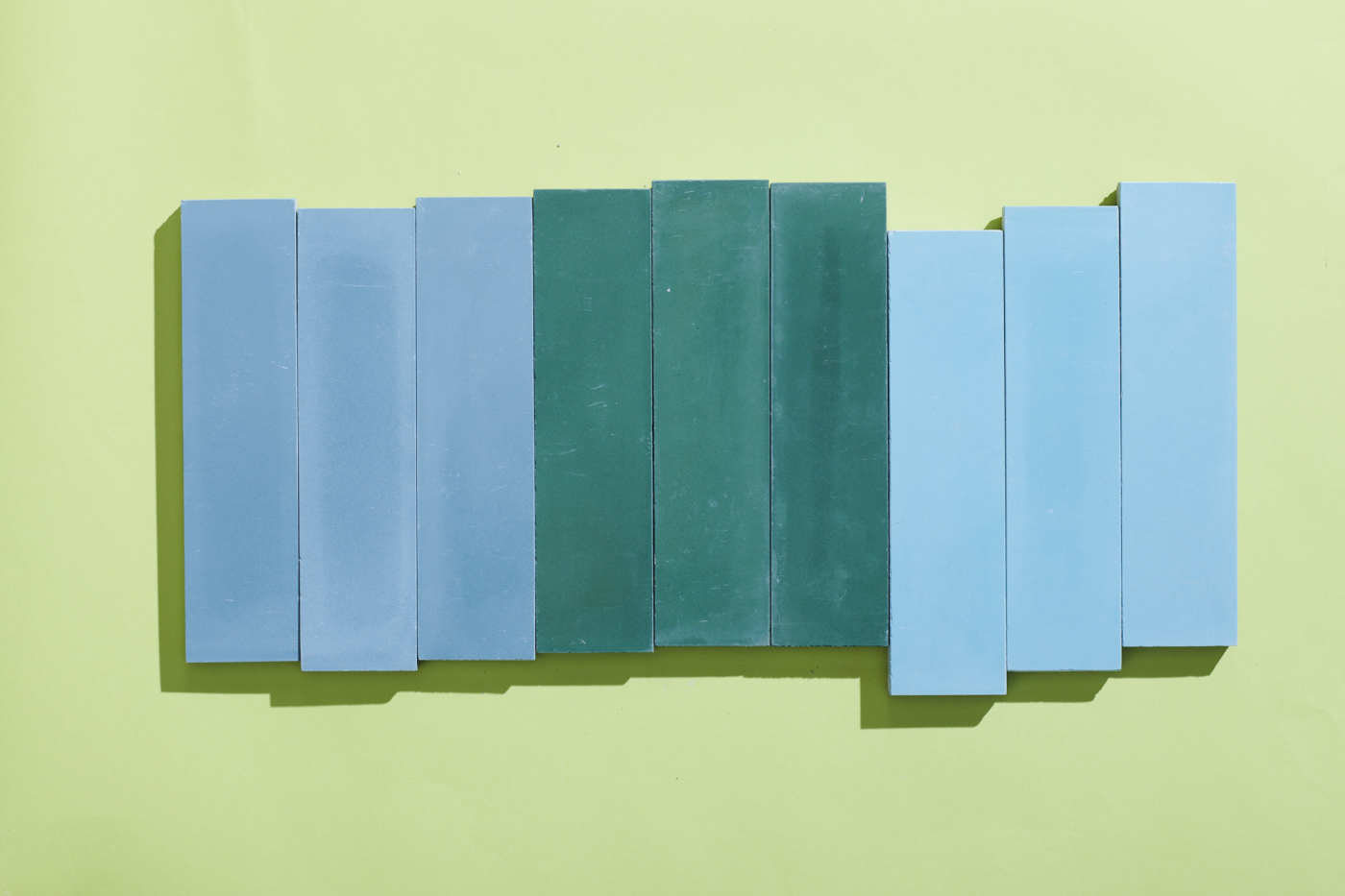 a group of blue and green tiles on a green wall.