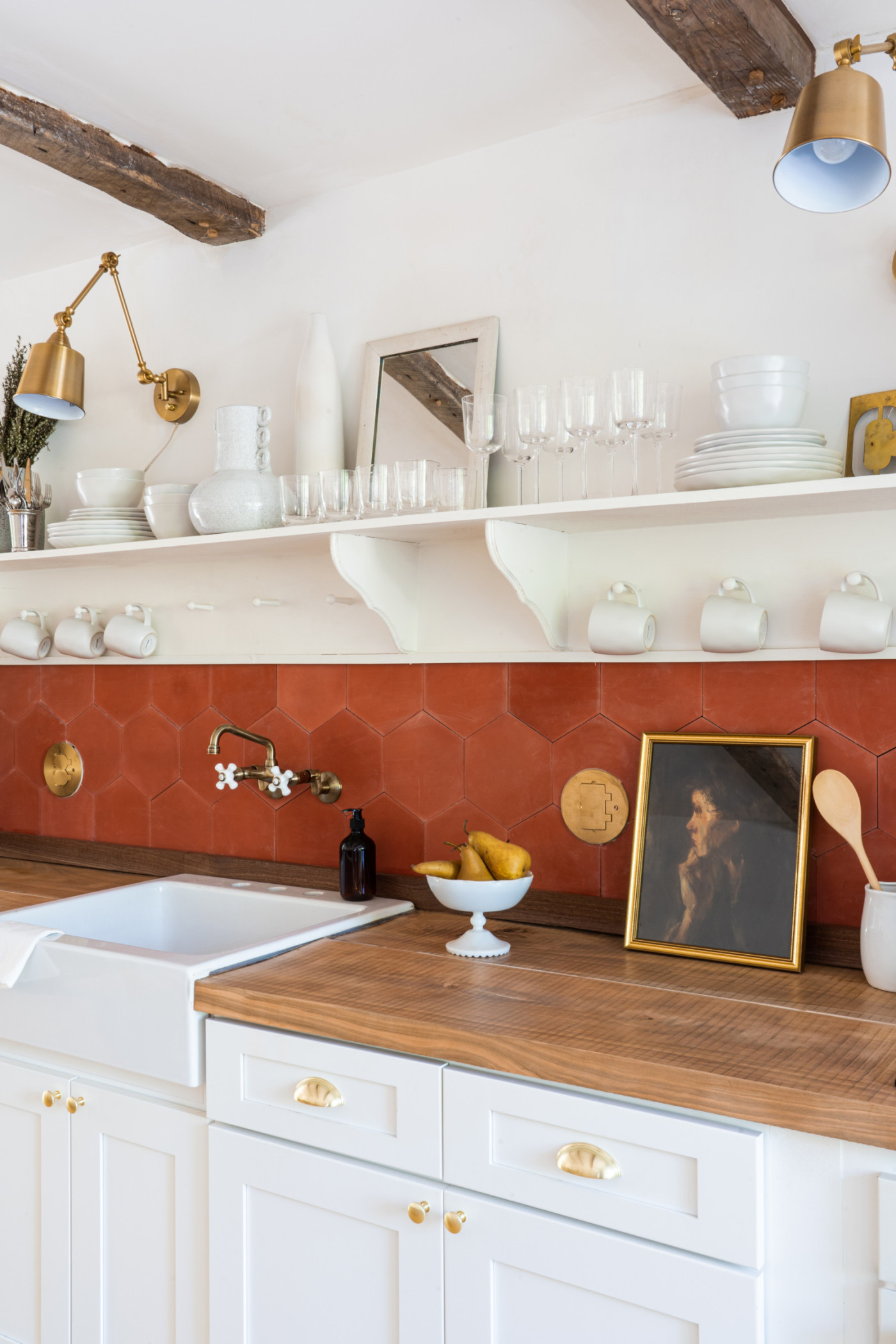 a white kitchen with a red tiled backsplash.