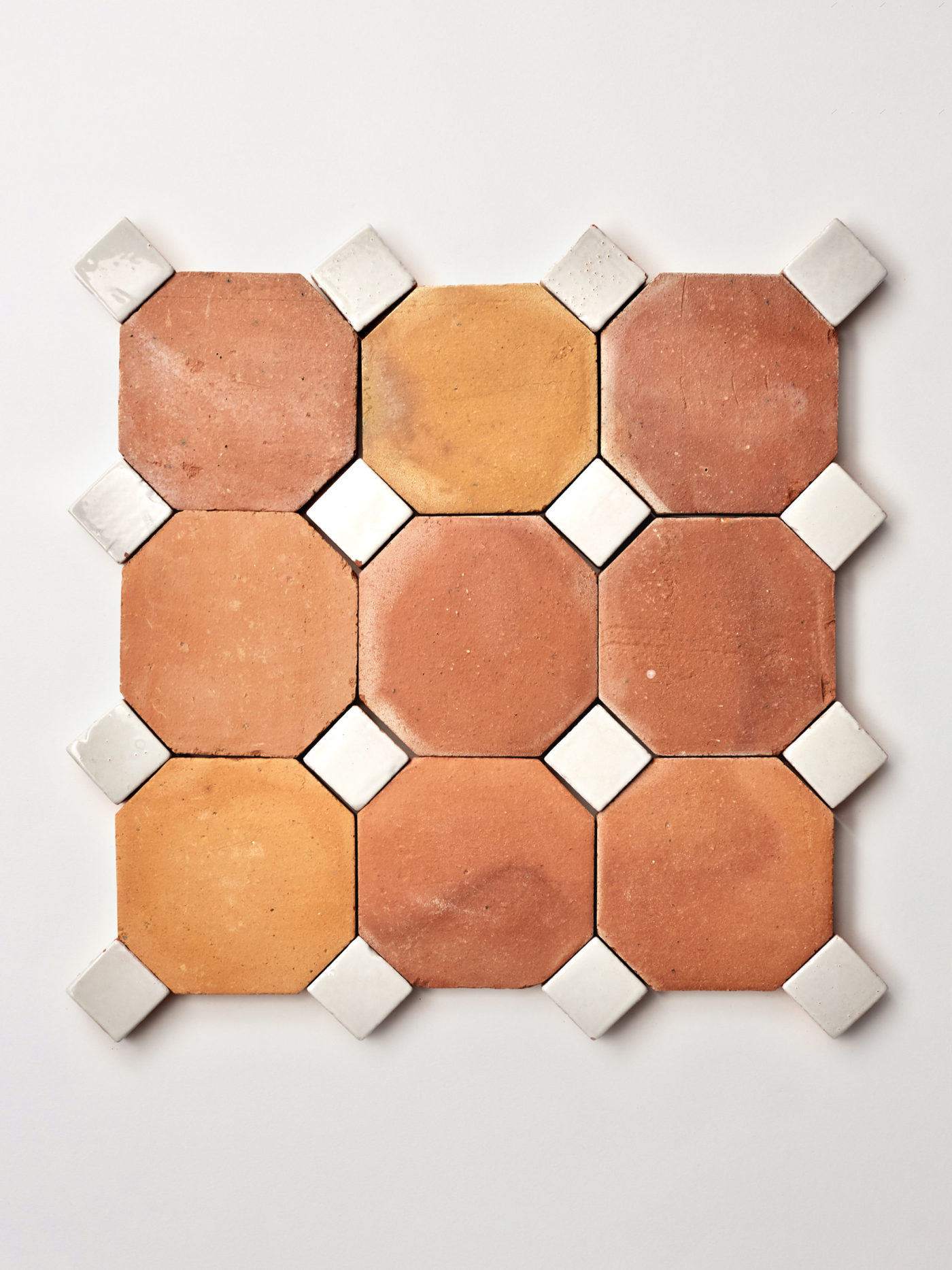 terracotta and white tiles arranged in a pattern on a white surface.