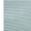 Honeycomb (cellular) shade, light-teal horizontal pleats, fully lowered; closed, softly diffusing light; close-up studio view against a white background.